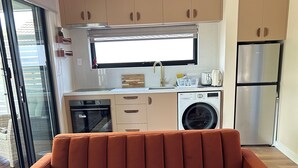 A modern kitchen with a built-in oven, microwave, and stainless steel refrigerator.