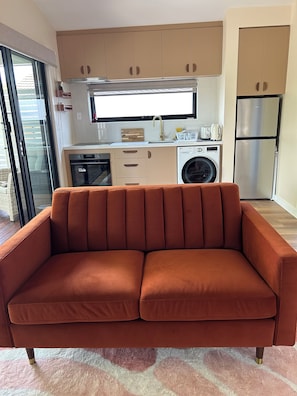 Een moderne keuken met een inbouwoven, magnetron en een koelkast van roestvrij staal.