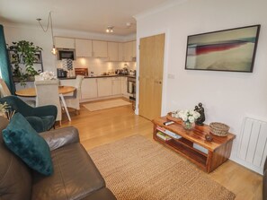 Uma sala moderna com um sofá de couro, uma mesa de centro e uma área de jantar com uma cadeira e mesa.