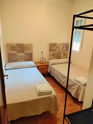Tabla de planchar con plancha y ropa de cama