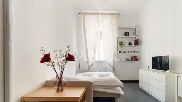Una camera da letto con un letto, un comodino e una televisione.
