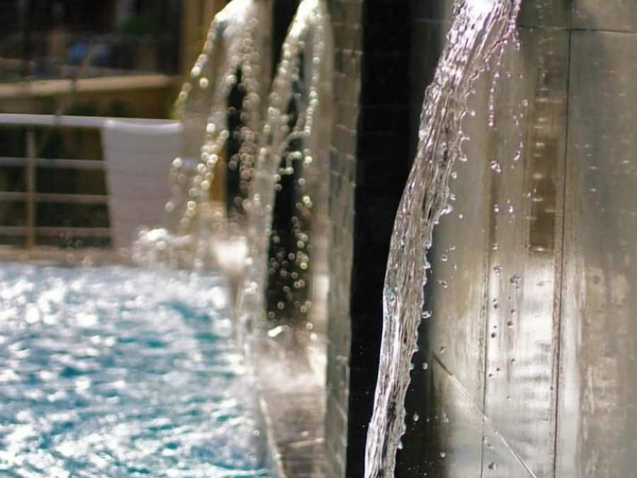 Um espelho de água com várias correntes de água a desaguar numa piscina.