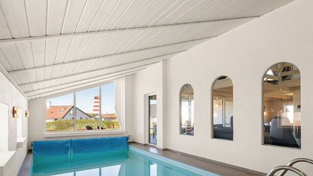 En swimmingpool med udsigt til bygninger, et blåt håndklæde og et glasindrammet område.