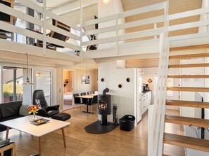 Ein modernes Interieur mit Essbereich, Kamin und Küche.