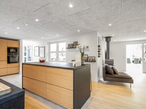 Eine moderne Küche mit Holzausstattung, einer Kochinsel und integrierten Geräten.