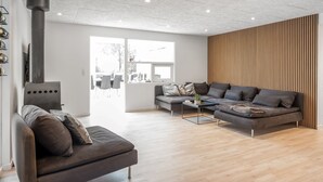 En moderne stue med sofa, sofabord og pejs.