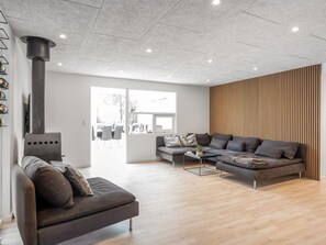 Ein modernes Wohnzimmer mit einer Couch, einem Couchtisch und einem Kamin.