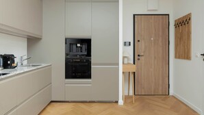 Cocina compacta con horno integrado, cafetera y lavabo.