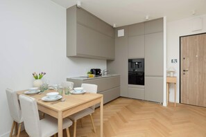 Eine moderne Küche mit Essbereich, Backofen und einem kleinen Beistelltisch.