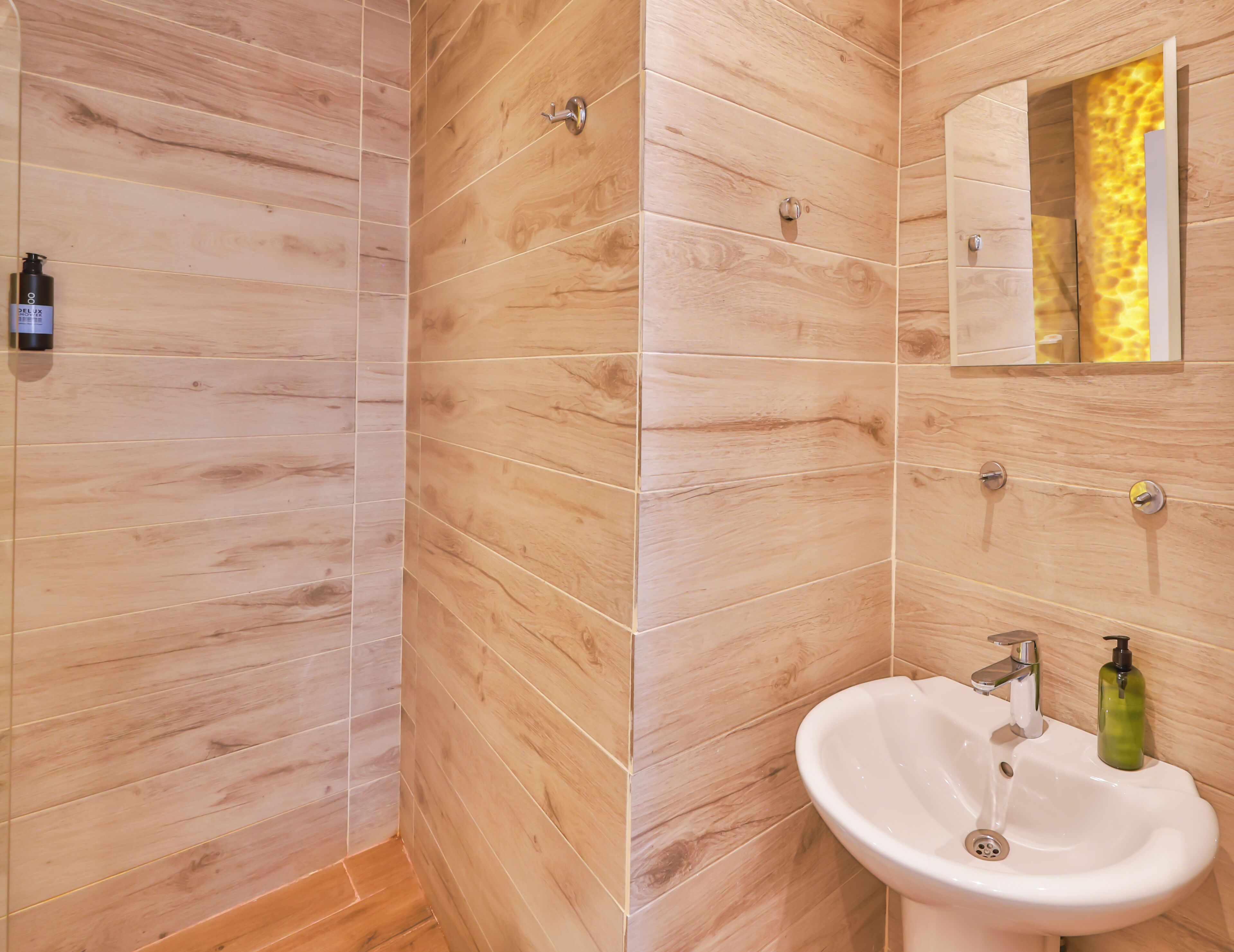 A bathroom with wooden panel walls, a white sink, and a mirror.