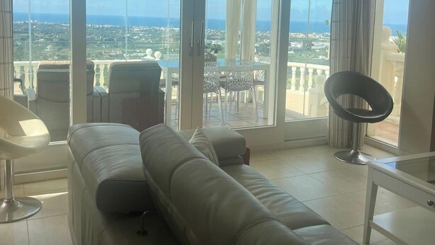 Una sala moderna con un sofá grande, una mesa de comedor y una silla.