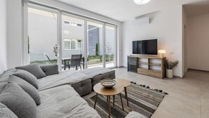 Un salon moderne avec un canapé, un téléviseur et une petite table.