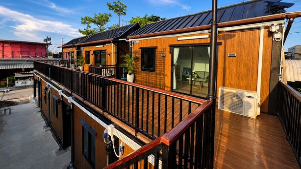 A multi-story building with wooden exterior, balconies, and solar panels. - Near BKK Homestay Airport (Bang Phli)