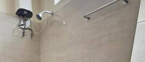 A bathroom with a toilet, shower, and sink.
