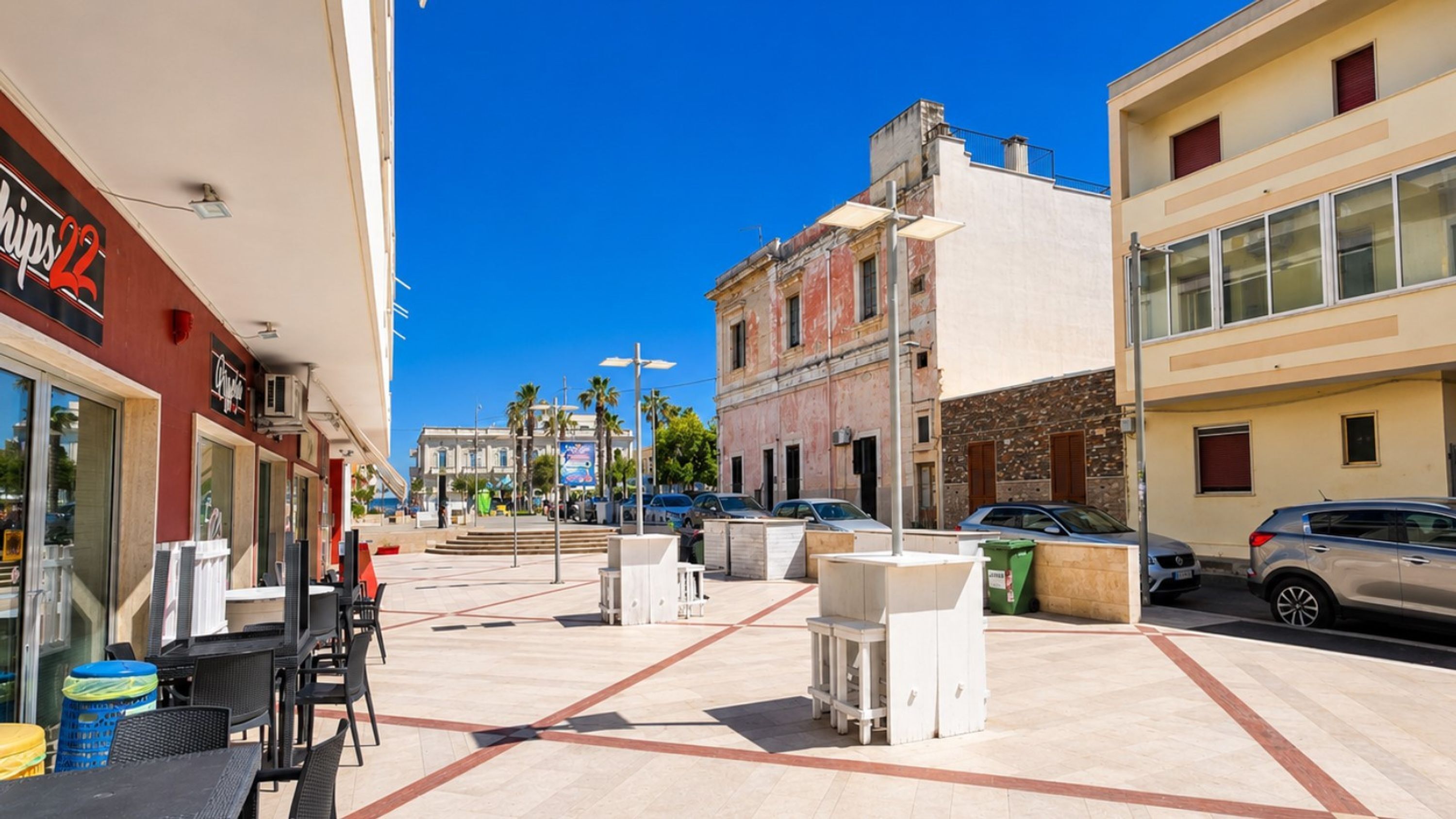 A public square with outdoor seating, a fountain, and buildings with commercial establishments.