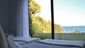 Ein Schlafzimmer mit Meerblick und einer Rasenfläche.
