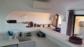 Eine moderne Küche mit Einbauofen, Spüle und Essbereich inklusive Sofa und Tisch.
