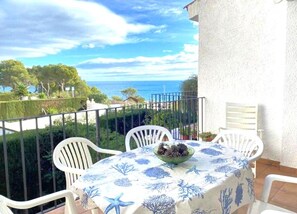 A balcony with a table and chairs, overlooking a coastal landscape. - Casa Cala Bot - Private Mediterranean escape in Costa Dorada (Miami Platja)