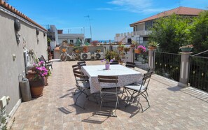 A patio with a table and chairs, surrounded by potted plants and a bicycle. - La Dimora di Max Bright apt. with Terrace (Riposto)