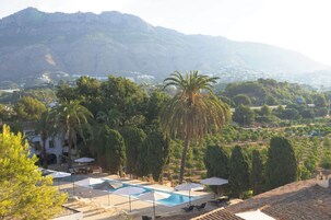 Ein Resort mit Schwimmbad, Liegestühlen und Sonnenschirmen.