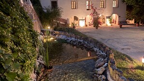 Un edificio con varias ventanas y un patio que incluye una fuente de agua.