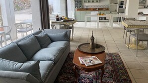 Amplia sala de estar con un sofá gris, una mesa de centro y una alfombra estampada.
