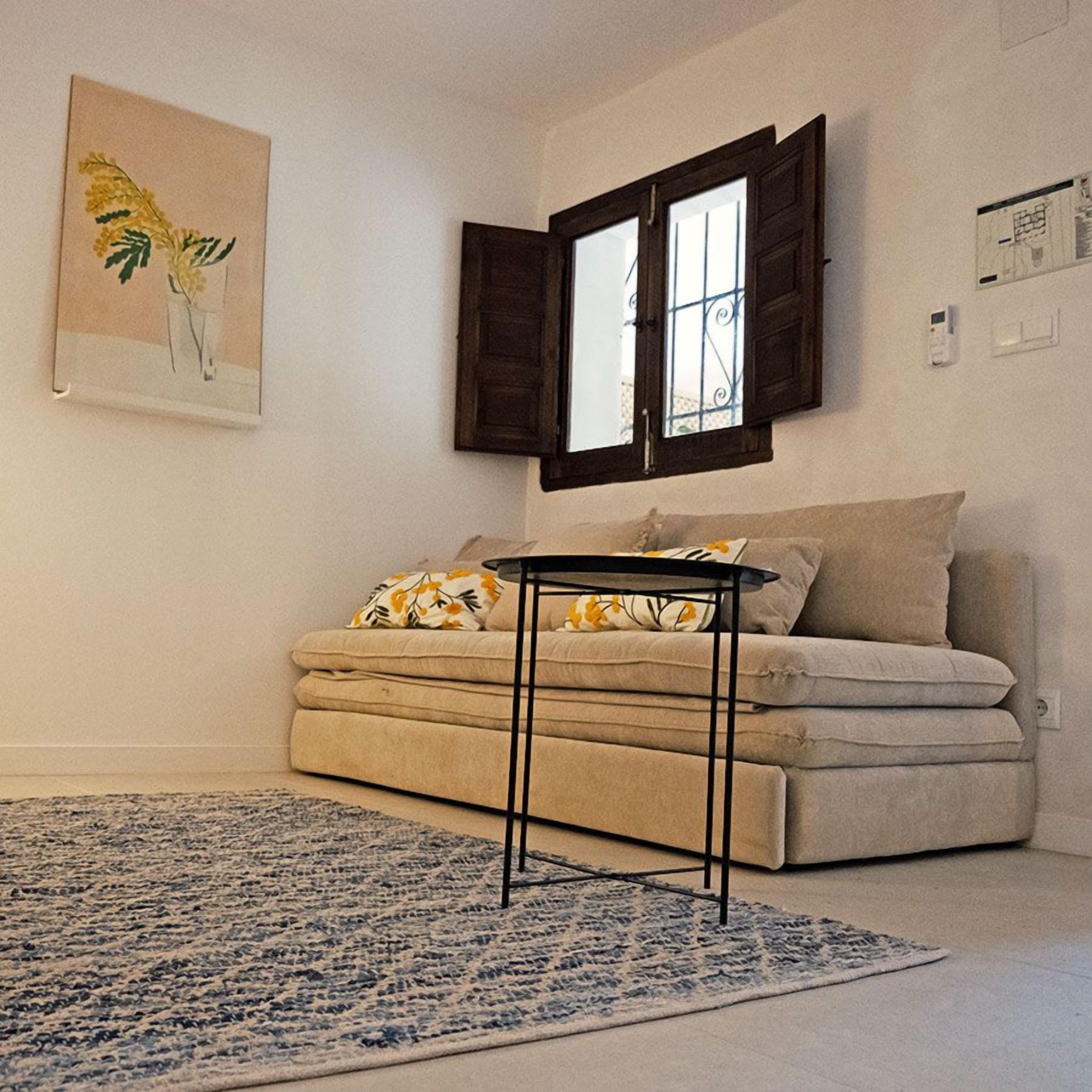 A living room with a sofa, a coffee table, and a patterned rug.