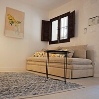 Ein Wohnzimmer mit einer Couch, einem Couchtisch und einem gemusterten Teppich.