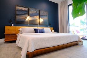 Ein Schlafzimmer mit einem hölzernen Bett, zwei Wandlampen und einem großen Fenster mit Blick.