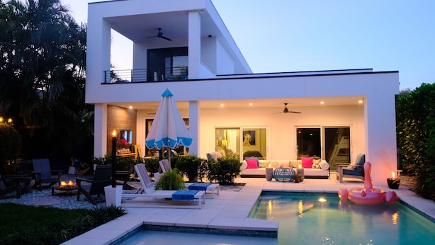 A modern two-story house with a swimming pool, outdoor seating, and a balcony. - Luxury Naples Private Retreat w/Resort Pool + Gym (Naples)