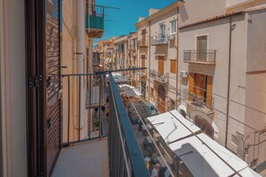 A narrow street with buildings on either side, balconies, and a clear blue sky. - Cocciu D'Amuri loft by Wonderful Italy (Cefalù)