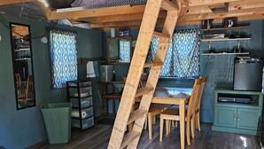 Een knus blokhutinterieur met een houten trap, een eethoek en een keuken.