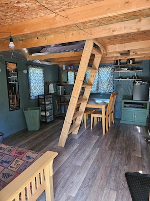 Ein rustikales Blockhaus-Interieur mit einer Holztreppe, einem Essbereich und einer Küche.