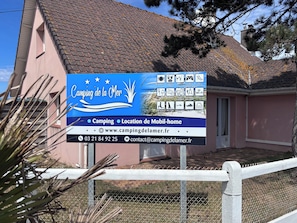 A signboard for Camping de la Men with amenities like camping, mobile home location, and contact information. - 1 min 50 from the beach. 2-bedroom bungalow. (Camiers)