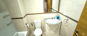 A bathroom with a toilet, sink, and mirror. - Apartment with pool and terrace near the beach - Costa Blanca (Guardamar del Segura)