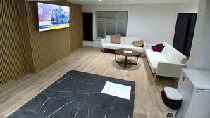 Una sala de estar moderna con un sofá, una mesa de centro y un televisor montado en la pared.