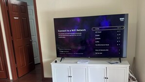 A television on a white cabinet with a menu for connecting to a WiFi network. - Welcoming 4-bedroom house in Anchorage for a relaxing stay (Anchorage)