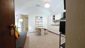 A room with a bed, a desk, a chair, a lamp, and a TV. - Hostdomus - Oscar's House (Albenga)