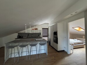 Eine moderne Küche mit einer zentralen Kochinsel, Barhocker und einem Essbereich.