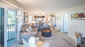 A spacious living room with a sofa, armchairs, a coffee table, and a dining area in the background. - RIVIERA CLUB BEACHFRONT RESORT CONDO w/ DIRECT GULF VIEWS! WRAP-AROUND LANAI! (Fort Myers Beach)