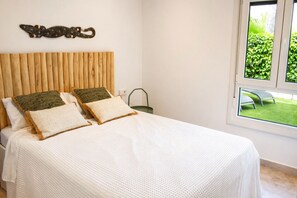 Ein Schlafzimmer mit einem hölzernen Kopfende, einer weißen Bettdecke und zwei Kissen.