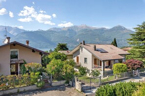 Zona residencial con casas, un jardín y una montaña al fondo.