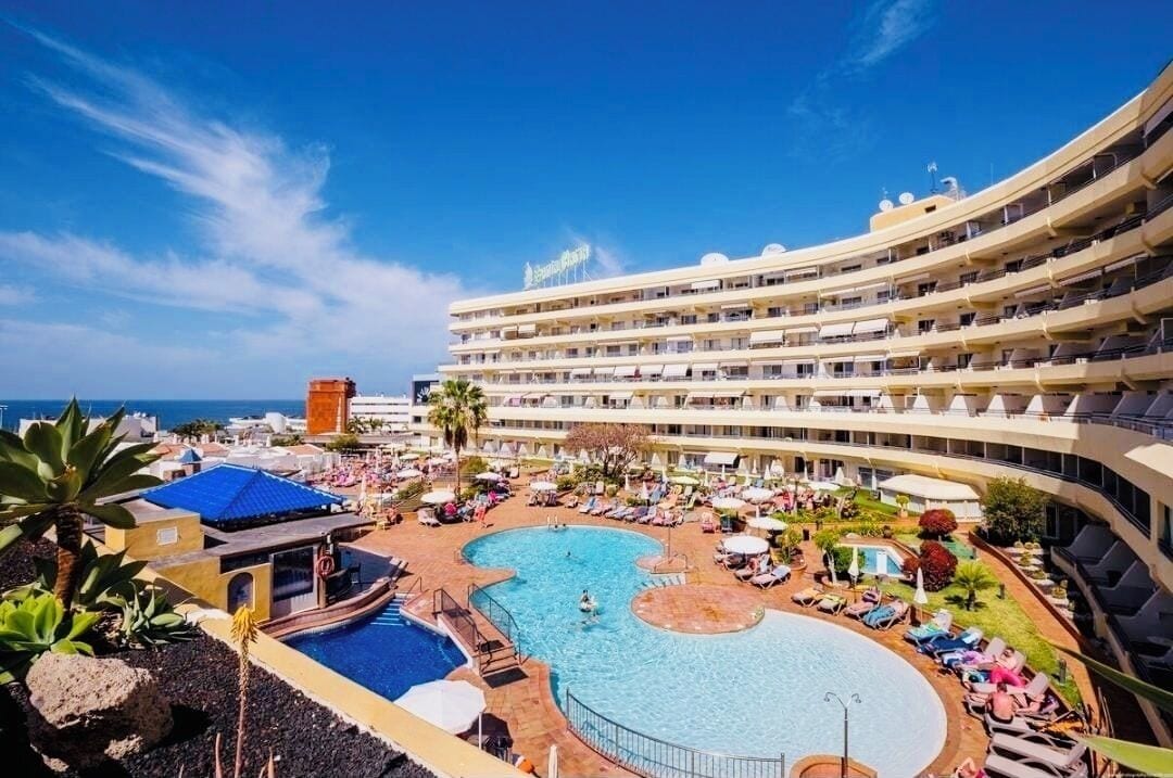 Un hôtel doté d’une grande piscine, de nombreux balcons et offrant une vue sur l’océan.