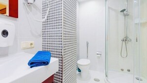 Ein modernes Badezimmer mit Duschkabine aus Glas, einem weißen Waschbecken und einer Wand mit Muster.