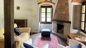 Uma sala de estar com lareira, sofá, mesa de centro e abajur.
