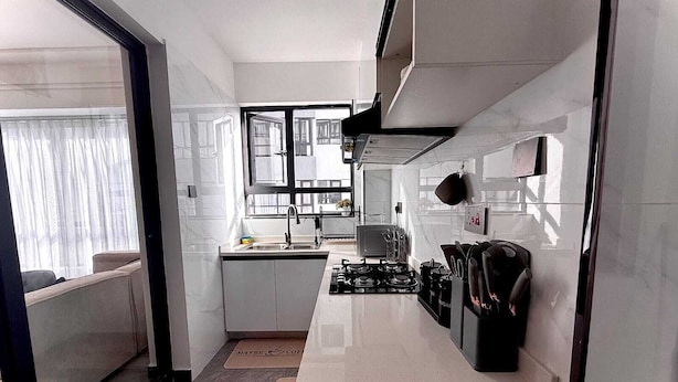 A modern kitchen with a gas stove, sink, and knife block. - Urban stays (Nairobi)