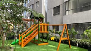 A children's play area with a slide, climbing structure, and swing set. - Urban stays (Nairobi)