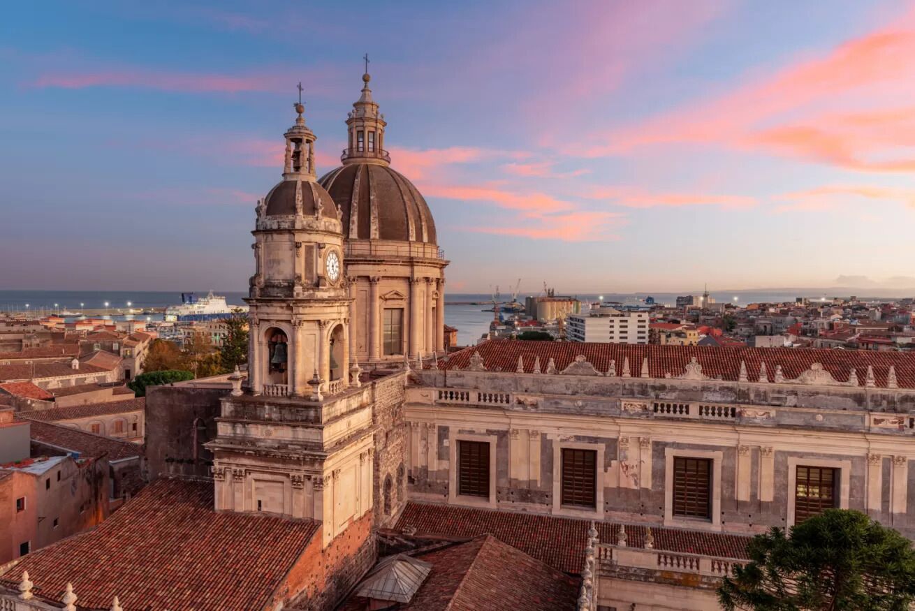 Un edificio histórico con una cúpula destacada y un campanario, rodeado de arquitectura tradicional.