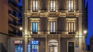 Ein mehrgeschossiges Gebäude mit einer klassischen Fassade, großen Fenstern und Balkonen.