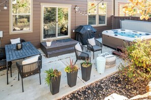 Eine Terrasse mit Whirlpool, Sitzgelegenheiten und Pflanzkübeln.